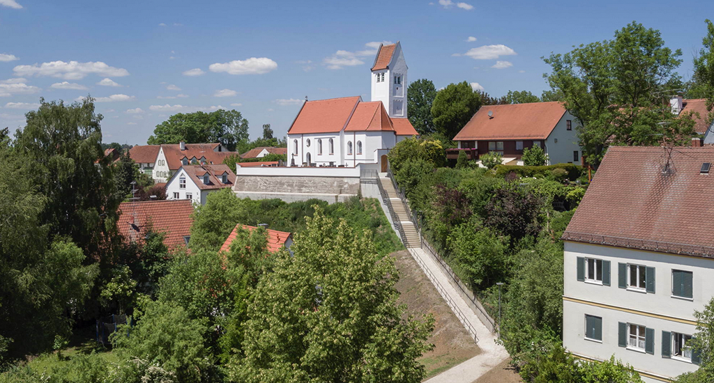 Schön gelegen, aber von unten etwas mühsam zu erklimmen: der Freidhof und die sanierte Kirche Sankt Georg (Bild: Florian Holzherr)
